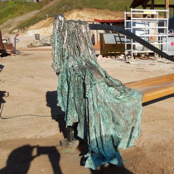 Patinating bronze statue on a bench